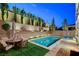 Private backyard pool featuring a patio area and lush landscaping, creating a serene outdoor space at 361 Cooper Hawk Ct, Las Vegas, NV 89138