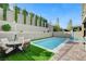 Backyard oasis featuring a pool, outdoor seating, built-in grill, and manicured landscaping at 361 Cooper Hawk Ct, Las Vegas, NV 89138