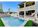 Back exterior view of a home with a pool and covered patio seating area at 361 Cooper Hawk Ct, Las Vegas, NV 89138