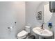 Well-lit powder room features a contemporary toilet, pedestal sink, modern fixtures and neutral décor at 361 Cooper Hawk Ct, Las Vegas, NV 89138