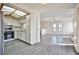 Open kitchen view with white cabinetry, stainless steel appliances, and gray wood flooring at 4083 Nook Way # D, Las Vegas, NV 89103