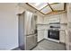 Kitchen with stainless steel refrigerator, oven, microwave, light wood-trimmed skylight, and white cabinets at 4083 Nook Way # D, Las Vegas, NV 89103