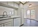 Kitchen sink with white counters and cabinetry facing wood-look patio doors with exterior view at 4083 Nook Way # D, Las Vegas, NV 89103