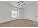 Cozy bedroom with carpet, a ceiling fan, and views of the outdoors at 4800 Grey Wolf Ln # 202, Las Vegas, NV 89149