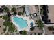 An aerial shot showcases a community pool with palm trees and lounge chairs at 4800 Grey Wolf Ln # 202, Las Vegas, NV 89149