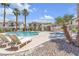 Community pool area showcasing clear water, palm trees, and lounge chairs at 4800 Grey Wolf Ln # 202, Las Vegas, NV 89149