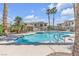 Community pool area showcasing clear water, palm trees, and lounge chairs at 4800 Grey Wolf Ln # 202, Las Vegas, NV 89149
