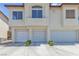 Three car garage showing the exterior of this light colored two-story townhouse at 4800 Grey Wolf Ln # 202, Las Vegas, NV 89149