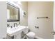 View of a half bathroom featuring a pedestal sink, decorative mirror and tiled floors at 5079 Quiet Falls Ct, Las Vegas, NV 89141