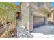 Charming home exterior featuring a brown garage, staircase, and garden at 5079 Quiet Falls Ct, Las Vegas, NV 89141