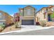 Two-story home showcasing desert landscaping, a spacious driveway, and attached garage at 5079 Quiet Falls Ct, Las Vegas, NV 89141