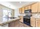 Modern kitchen with granite countertops, stainless steel appliances, and an island with bar seating at 5079 Quiet Falls Ct, Las Vegas, NV 89141