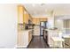 View of the kitchen featuring hardwood floors, wood cabinets, stainless steel refrigerator and granite countertops at 5079 Quiet Falls Ct, Las Vegas, NV 89141