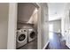 A convenient laundry closet features tile floors and newer model, front-loading washer and dryer at 5079 Quiet Falls Ct, Las Vegas, NV 89141