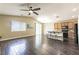 Spacious living room featuring hardwood floors and a ceiling fan, adjacent to the kitchen and dining area at 5079 Quiet Falls Ct, Las Vegas, NV 89141