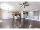 Inviting living room featuring hardwood floors, a ceiling fan, and an open layout connected to the kitchen at 5079 Quiet Falls Ct, Las Vegas, NV 89141