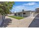 The backyard has artificial turf, a covered patio, and mature trees, with block fencing at 5079 Reno Ct, Las Vegas, NV 89119