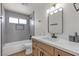 Well-lit bathroom featuring a shower-tub combo, modern vanity, and stylish gray backsplash at 5079 Reno Ct, Las Vegas, NV 89119
