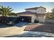 Two-story home with desert landscaping, a driveway, and a two-car garage with vehicles in the driveway at 6024 Ripple Cloud Ct, North Las Vegas, NV 89031