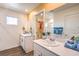 Bathroom with double sink vanity, quartz countertop, wood look flooring, and walk-in closet with hanging clothing at 6521 Cinnamon Hazelnut St # Lot 91, North Las Vegas, NV 89084