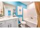 Bright bathroom showcasing a white vanity, toilet, and tub with blue accent wall and decorative art at 6521 Cinnamon Hazelnut St # Lot 91, North Las Vegas, NV 89084