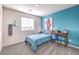 Modern bedroom with blue accent wall, desk, and twin bed offering comfortable living space at 6521 Cinnamon Hazelnut St # Lot 91, North Las Vegas, NV 89084