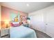 Comfortable bedroom with a twin bed, stylish desk, closet, and soft pink accent wall at 6521 Cinnamon Hazelnut St # Lot 91, North Las Vegas, NV 89084