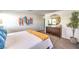 Bright bedroom featuring a modern dresser with round mirror and white comforter with yellow throw blanket at 6521 Cinnamon Hazelnut St # Lot 91, North Las Vegas, NV 89084