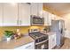 Modern kitchen features stainless steel appliances, gray quartz countertops, and white cabinets at 6521 Cinnamon Hazelnut St # Lot 91, North Las Vegas, NV 89084