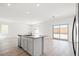 Bright, modern kitchen with a kitchen island, stainless steel appliances, and an open view to the living room at 6712 Violet Cascade Ave, Las Vegas, NV 89156