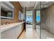 Modern bathroom featuring double sinks, sleek cabinetry, and a glass-enclosed shower with stylish tile work at 677 Overlook Rim Dr, Henderson, NV 89012