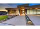 Modern home featuring clean architecture, a three-car garage, and desert landscaping with rock ground cover at 677 Overlook Rim Dr, Henderson, NV 89012