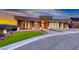 Contemporary home featuring modern architecture, a three-car garage, desert landscaping, and a well-manicured lawn at 677 Overlook Rim Dr, Henderson, NV 89012
