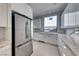A contemporary kitchen showcases a stainless steel refrigerator and white cabinets and drawers at 677 Overlook Rim Dr, Henderson, NV 89012
