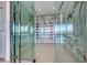 Contemporary wine cellar with glass doors, marble walls, and stylish bottle racks with colorful accents at 677 Overlook Rim Dr, Henderson, NV 89012