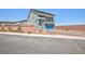 Two-story home with balcony, blue garage door and low maintenance landscaping behind a brick wall at 7828 Bright Lodge St, Las Vegas, NV 89139