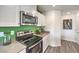 Clean kitchen with stainless steel appliances, white cabinets, and gray countertops at 7935 Pandora Sky St # 381, North Las Vegas, NV 89084