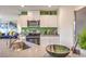 Modern kitchen with stainless steel appliances, white cabinets, and a green backsplash at 7935 Pandora Sky St # 381, North Las Vegas, NV 89084