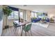 Bright living room with blue sofa, wood dining table and many windows at 7935 Pandora Sky St # 381, North Las Vegas, NV 89084