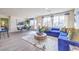 Bright living room with blue sofa, wood dining table and many windows at 7935 Pandora Sky St # 381, North Las Vegas, NV 89084