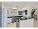 Well-lit kitchen featuring gray cabinetry, granite countertops, and a breakfast bar at 8040 Arcadian Ln, Las Vegas, NV 89147