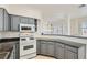 Kitchen with gray cabinets, granite counters, and modern appliances at 8040 Arcadian Ln, Las Vegas, NV 89147