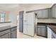 Modern kitchen featuring gray cabinets, granite countertops, tile floor and a large LG stainless steel refrigerator at 8040 Arcadian Ln, Las Vegas, NV 89147