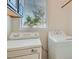 Functional laundry room with washer, dryer, window, and overhead storage for convenience at 8040 Arcadian Ln, Las Vegas, NV 89147