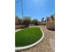 Landscaped backyard featuring lush green grass, a retaining wall, and a private outdoor space at 8397 San Ramon Dr, Las Vegas, NV 89147
