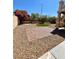 Backyard featuring manicured lawn, gravel, and a brick-paver patio at 8397 San Ramon Dr, Las Vegas, NV 89147