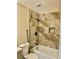The renovated bathroom features a shower-tub combo, modern fixtures, and beautiful marble-look tile surround at 8397 San Ramon Dr, Las Vegas, NV 89147