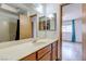 Bright bathroom featuring a long vanity with a solid surface top, wood cabinets and a tiled shower at 875 Rhinegold Way, Las Vegas, NV 89110