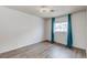 Light-filled bedroom with hardwood floors and blue curtains at 875 Rhinegold Way, Las Vegas, NV 89110