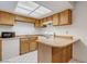 The kitchen offers wood cabinets, tiled floors, white appliances, and a breakfast bar at 875 Rhinegold Way, Las Vegas, NV 89110